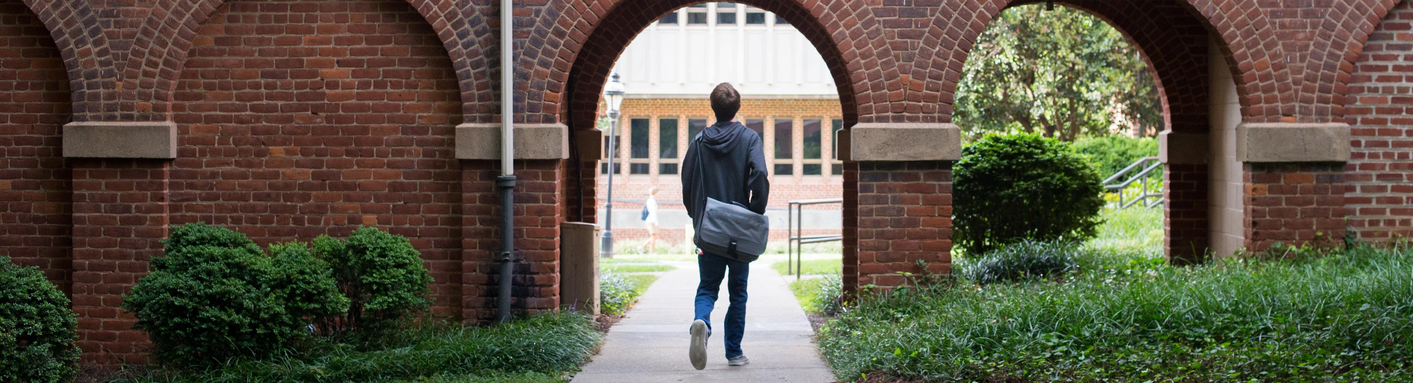 Photo of student walking through campus.