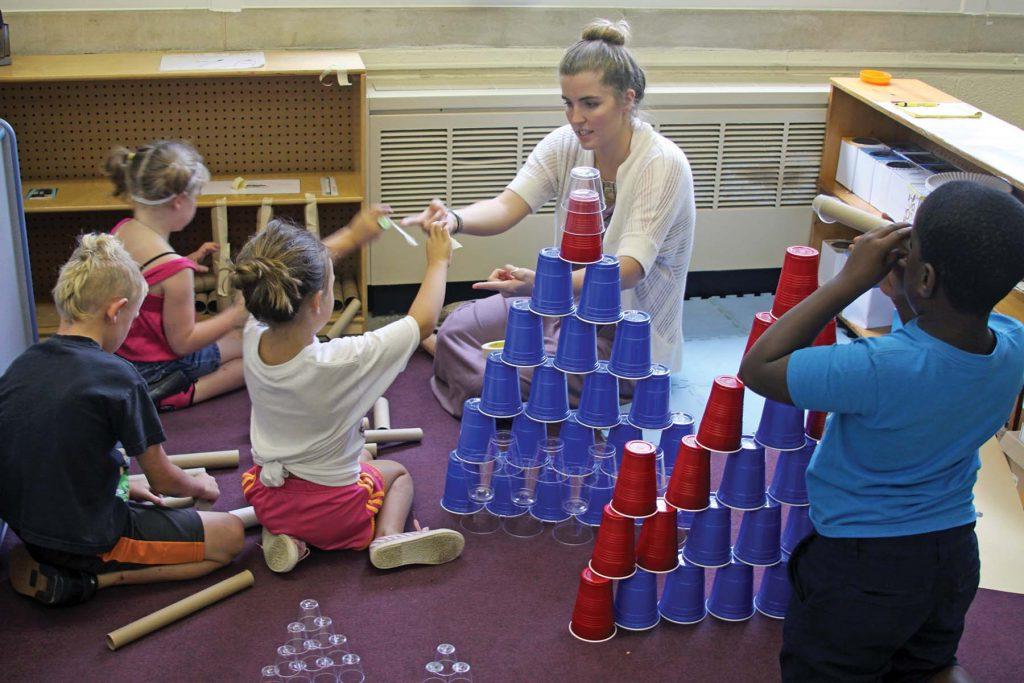Student teacher builds towers with schoolchildren.