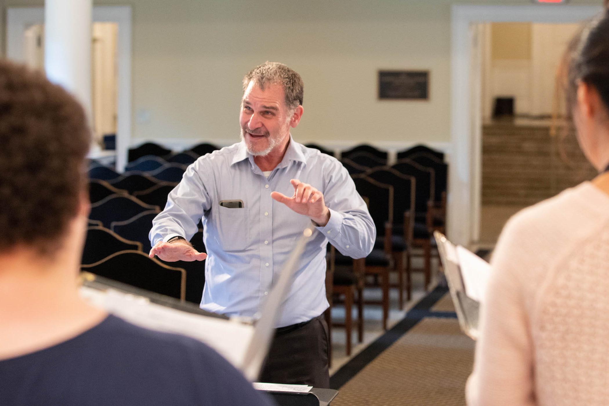 Professor Randall Speer conducts in rehearsal.